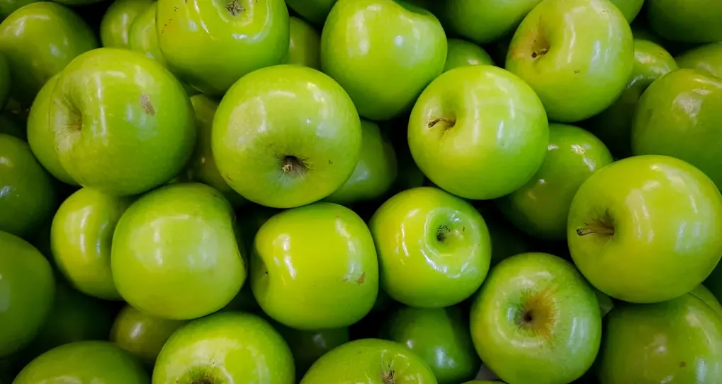 Maçãs verdes empilhadas em close